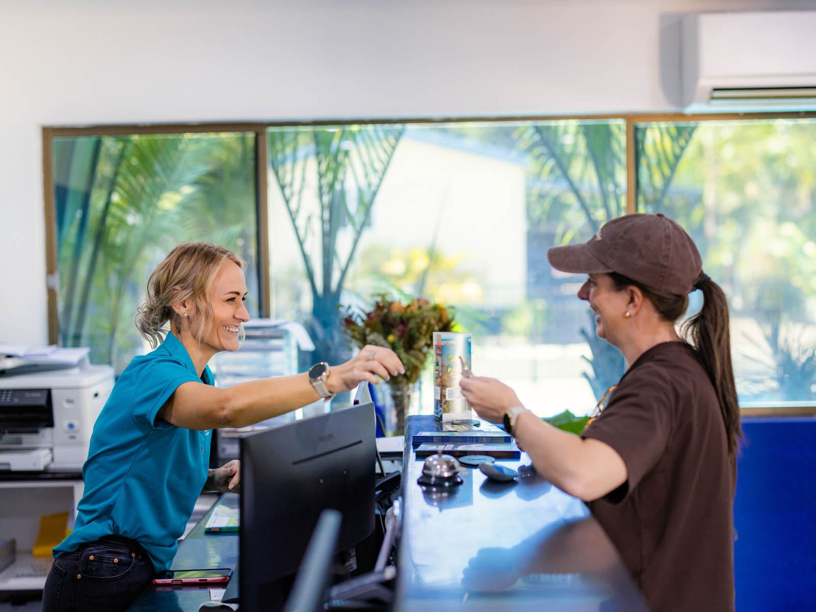 A staff member checking in a guest at reception
